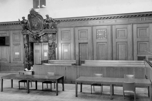 Blick auf die Anklagebänke vor Rückgabe des Schwurgerichtssaals 600 an die deutsche Justiz 1961. Die beiden Anklagebänke auf der rechten Seite, die nicht überliefert sind, waren deutlich breiter. Auf ihnen mussten jeweils sechs Angeklagte Platz nehmen.